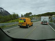 In Norwegen gibt es kaum Baustellenampeln, nur Flg meg Fahrzeuge die immer hin und her pendeln. Zwei Arbeiter halten in der Zwischenzeit den Verkehr auf.
