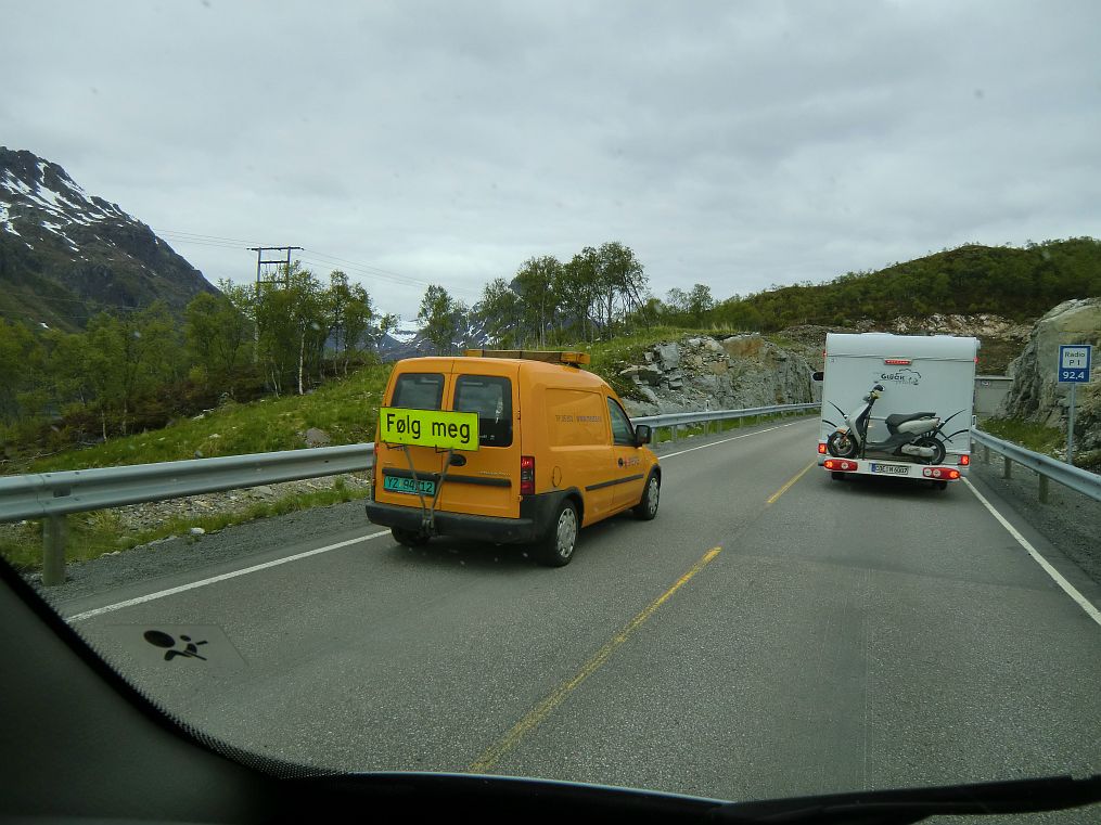 In Norwegen gibt es kaum Baustellenampeln, nur Følg meg Fahrzeuge die immer hin und her pendeln. Zwei Arbeiter halten in der Zwischenzeit den Verkehr auf.