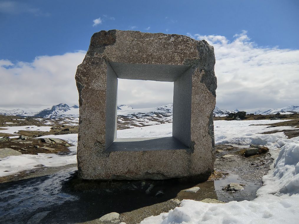 Auf dem Sognefjell, unweit des Rastplatzes Mefjell, bildet eine Steinskulptur des Künstlers Knut Wold den Rahmen für den Blick auf die Gletscherlandschaft am fernen Horizont.