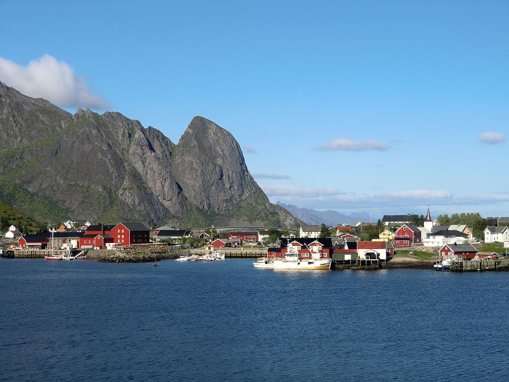Ein Blick auf Reine. Im Hintergrund eine Brücke der E10 und darüber der Hausberg von Hamnøya, der 700 m hohe Lilandstinden