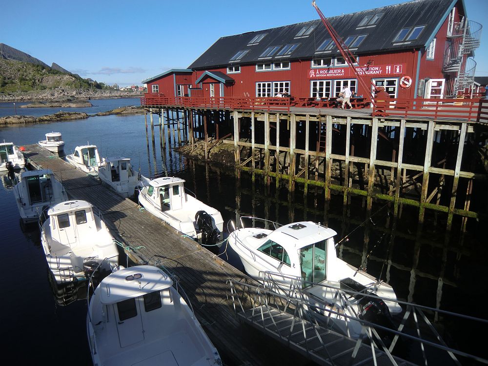 Unten liegen die Fischerboote bereit zum mieten und oben sitz man auf der Terrasse des Brygga Restaurants